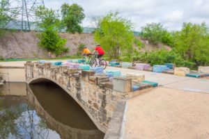 Bicyclists on Mission Reach bridge near Concepcion Park